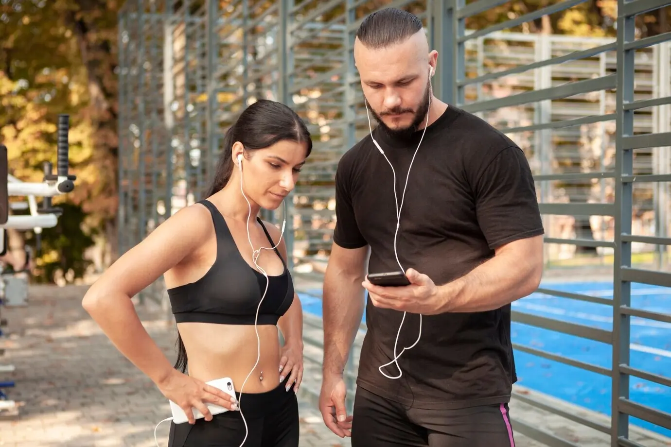 Друзья-спортсмены с мобильными телефонами и наушниками.